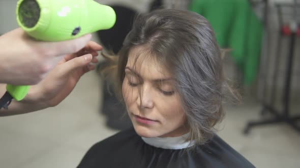 Professional Hair Dresser Using a Hairdryer After Haircut