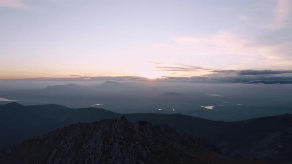 Mountain silhouettes under cloudy sky at dusk