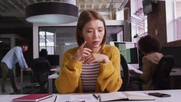 Happy mixed race businesswoman having video call sitting in front of computer