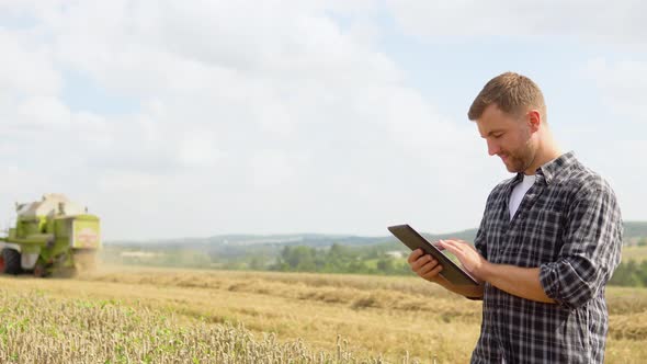 Farmer in Wheat Field Holding Digital Tablet