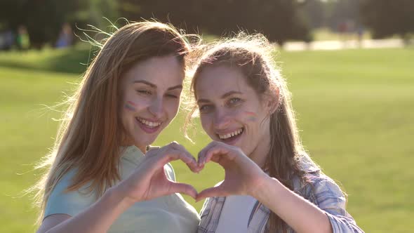 Portrait of Smiling Lesbians Showing Hand Heart