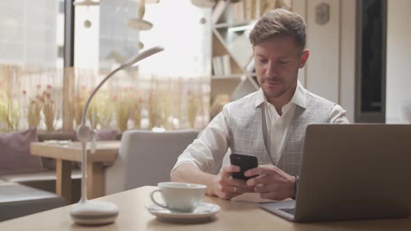 Businessman sitting and working in a cafe. Man using computer.