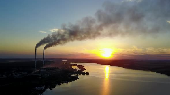 Industrial Building In Country Side. Pipe with smoke near people which spend time near river