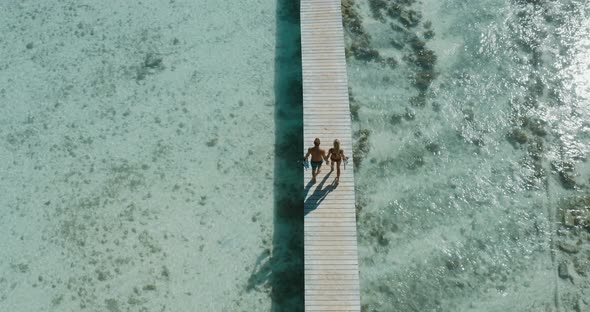 Couple walking on a wooden dock together