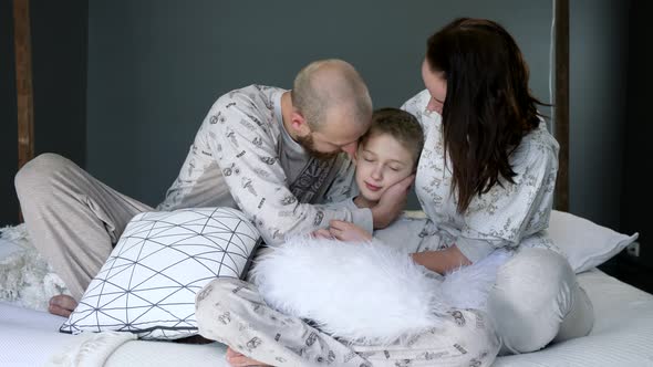 Family Photoshoot in Pajamas on Bed with Pillows, Happy Parents with Son at Bedroom