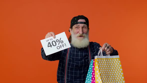 Senior Bearded Man Showing Shopping Bags and Up To 40 Percent Off Inscriptions Banner Black Friday