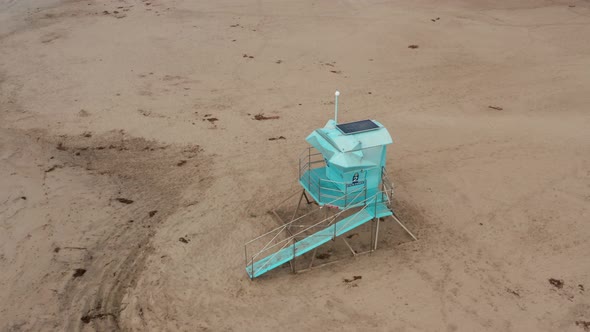 Drone shot rotating around Life guard tower on beach of Santa Cruz