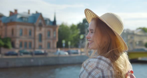 Young Blonde Woman on Vacation Smiling Happy Standing on Embankment in City