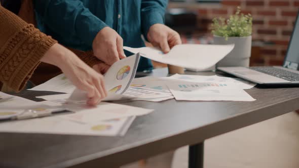 Close Up of Colleagues Analyzing Data Rate Charts on Papers