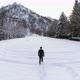 Forward Aerial Over Man Walking with Snowshoes on Mountain Snow Covered Field Near Pine Forest Woods - VideoHive Item for Sale