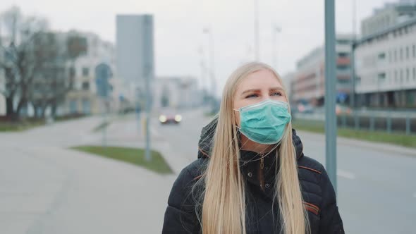 Concerned Woman in Medical Coronavirus Mask Walking on the Street