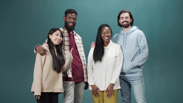 Cheerful Diverse People Huddling and Laughing on a Green Background