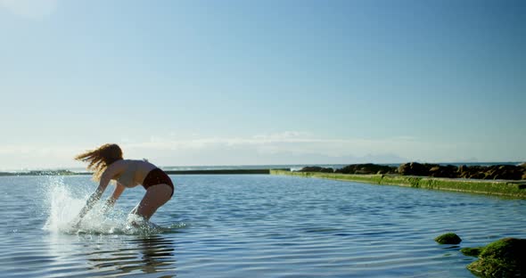 Woman playing with water at beach 