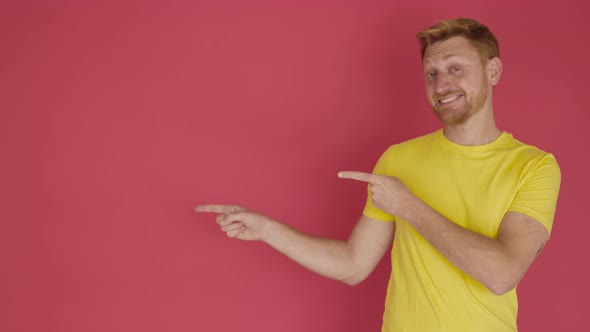 Smiling Young Adult Man Pointing with Fingers Over Isolated Red Background