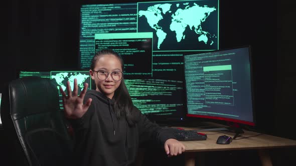 Young Hacker Hacking With Multiple Computer Screens And Looking At Camera During Showing Stop Hand