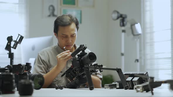 An Asian man is removing a series of camera rigs