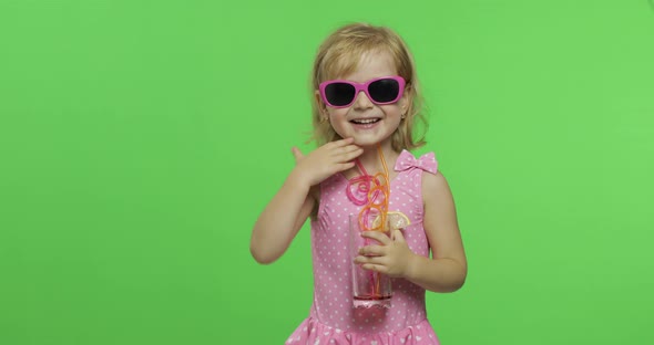 Child in Pink Swimsuit Drinks Juice Cocktail with Drinking Straw. Chroma Key