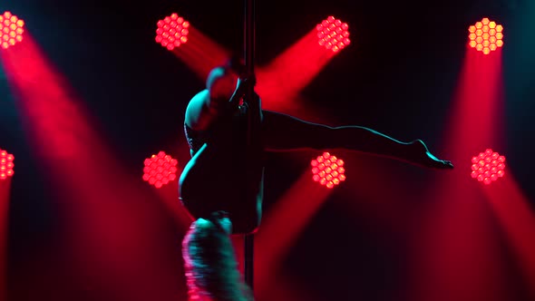 Silhouettes of a Slender Exotic Dancer Rotating Beautifully on a Pole