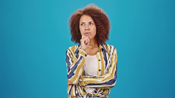 Pensive Woman Crosses Arms Trying to Think of Good Plan