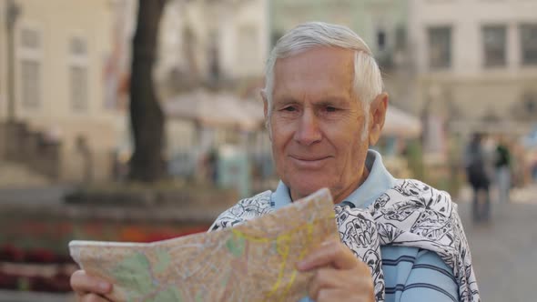 Senior Male Tourist Exploring Town with a Map in Hands. Looking for the Route