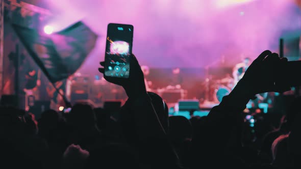 People Filming Rock Concert on Smartphones Silhouettes Crowd of Fans Dancing