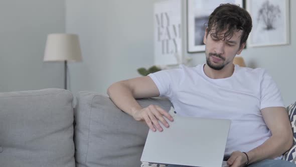 Young Man Leaving Couch After Completing Work on Laptop