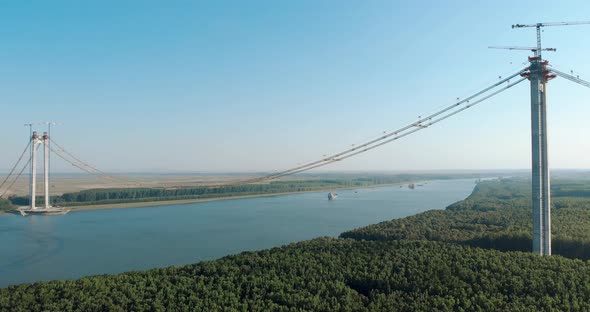 Approaching Ships Across Danube River With Braila-Tulcea New Bridge In Eastern Romania. Wide Shot