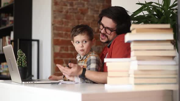 father with a son at working place in home office