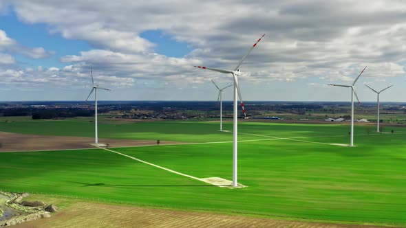 Flying above white wind turbines in spring, Poland