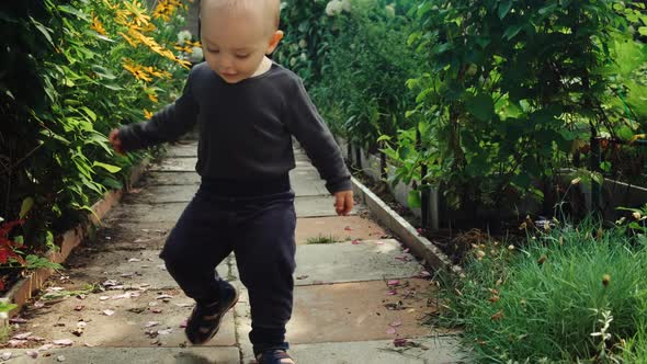 Joyful Little Baby Boy Walking in the Backyard Garden