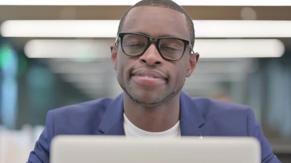 African Businessman with Laptop Smiling at Camera