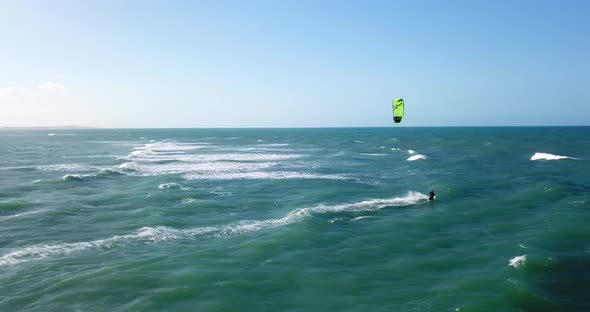 Aerial drone view of a man kiteboarding on a kite board.