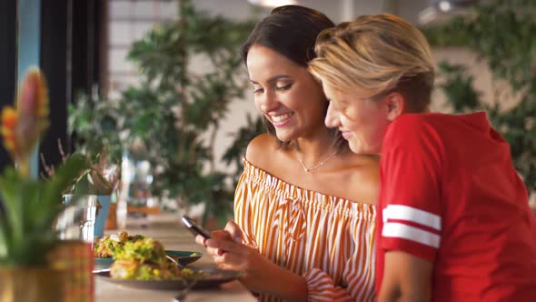 Female Friends with Smartphone at Restaurant 