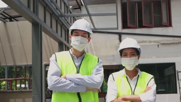 Asian workers people wearing protective face mask onsite of architecture due to Covid 19 pandemic.