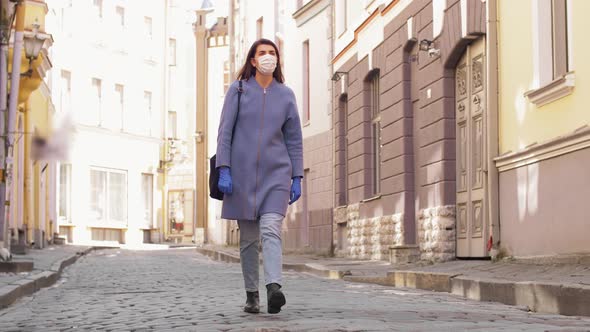 Woman Wearing Mask and Gloves Walking in City