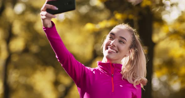 Autumn Selfie, Positive Blonde Lady Recording Video on Smartphone in Fall Park, Slow Motion