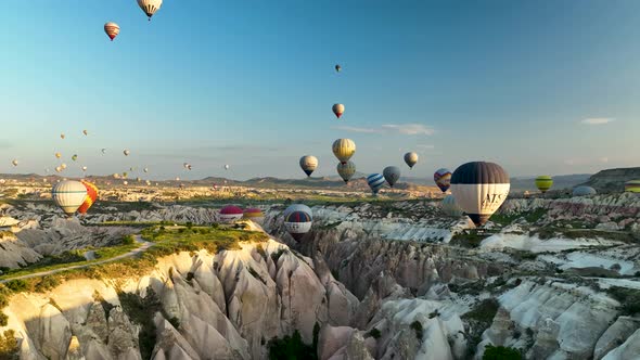 4K Aerial view of Goreme. Colorful hot air balloons fly over the valleys.