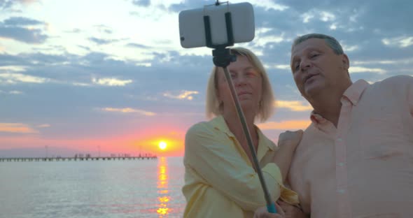 Couple on vacation taking selfie at sunset