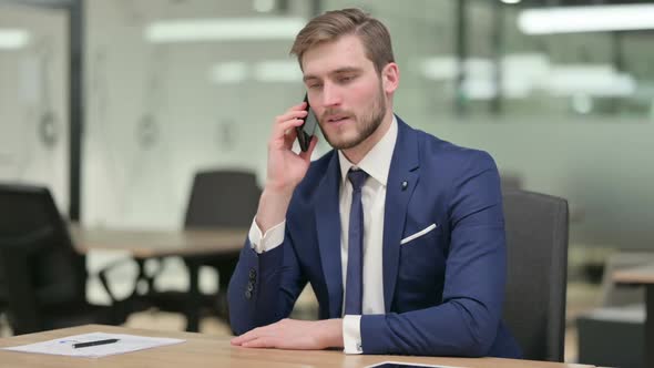 Businessman Talking on Phone at Work