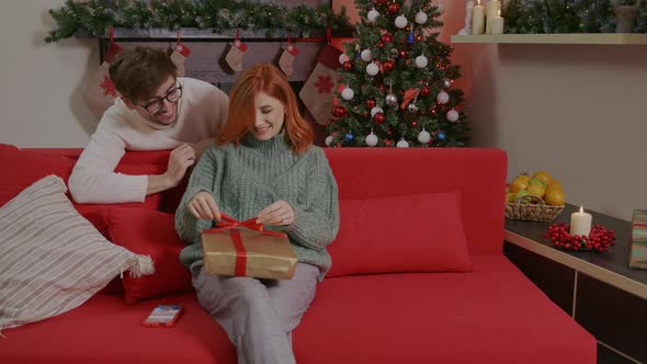 Happy man is making christmas gift to his beloved woman.