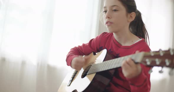 young girl playing guitar and singing