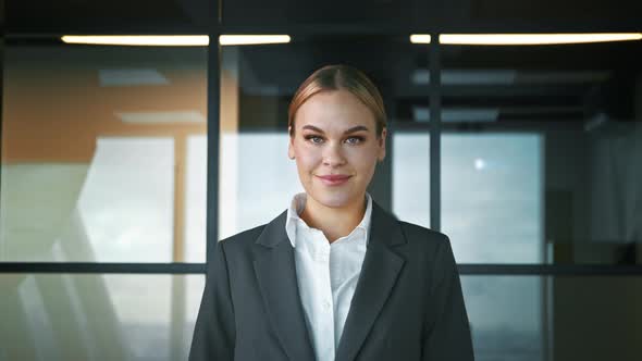 Smiling woman in a suit in the office. Businesswoman looking at camera