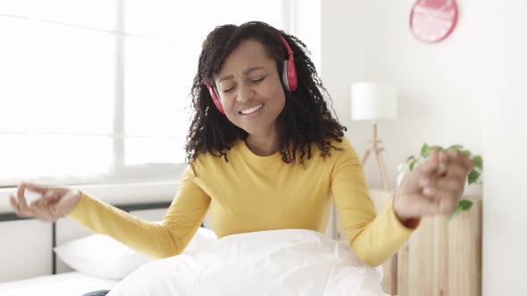 Joyful Young African American Woman Dancing While Listening to Music on Bedroom