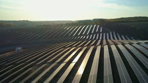 Aerial Drone Footage. Low Flight Above Solar Panel Farm at Sunset Autumn Season.