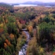 Aerial flythrough of Winding River Through Autumn Trees with Fall Colors in New England - VideoHive Item for Sale