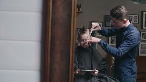 Kid Using Tablet During Haircut