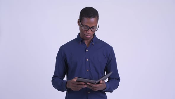 Young African Nerd Businessman with Eyeglasses Talking While Reading Book