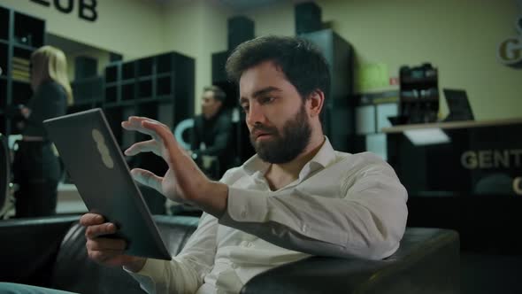 Young Caucasian Man Checking Social Medias on a Tablet PC