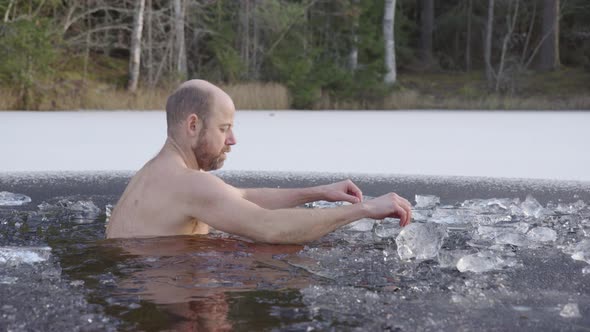 SLOW MOTION MS- A male ice bather sits down into the icy water to begin