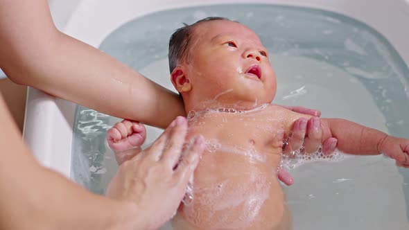 Calm of asian newborn baby bathing in bathtub